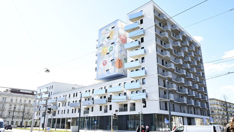 copyright: Stadt Wien/Christian Jobst Wohnhaus mit hellblauen Balkonen und einem Wandgemälde mit farbigen Schaltplatten