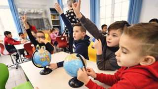 Buben in einer Schulklasse zeigen auf